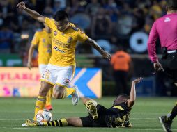 Lucas Zelayaran (i) de Tigres disputa el balón con Alberto Acosta (abajo) de Monarcas Morelia este sábado. EFE/M. Sierra