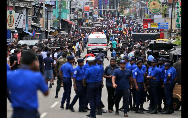 Se reportan al menos 450 heridos por los atentados. Policías despejan una calle en Colombo para dar paso a una ambulancia que traslada a heridos.