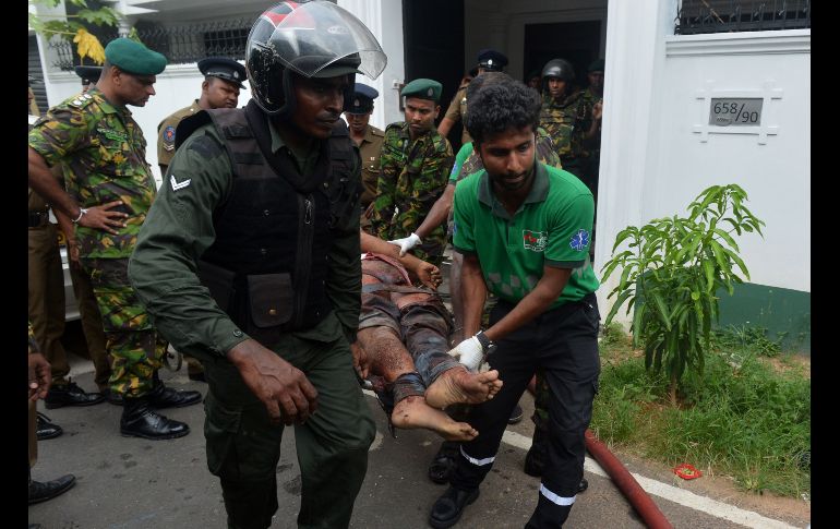 En Orugodawatta, al norte de Colombo, un kamikaze se inmoló en un edificio y mató a tres policías. Un polícia lesionado es sacado del sitio.