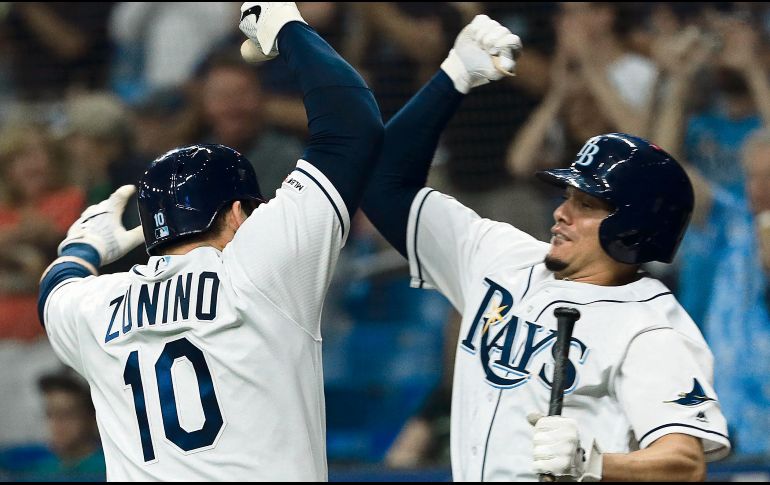 Mike Zunino (#10) celebra su jonrón con Daniel Robertson. AFP