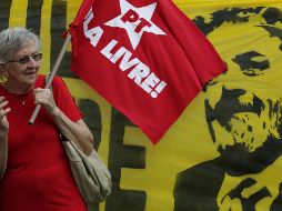 Una mujer sostiene una bandera del Partido de los Trabajadores durante una demostración de apoyo a Lula afuera de la Suprema Corte de Justicia. AP/E. Peres