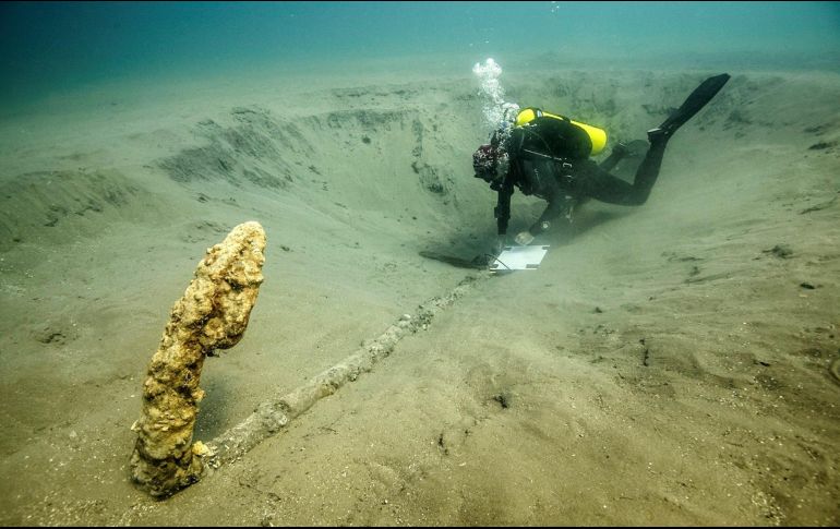 El elemento mide 2.59 metros de largo en su caña y conserva no sólo sus dos brazos de 33 centímetros cada uno, sino también su arganeo y parte de su cepo de madera. EFE/INAH