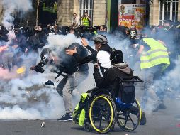 Un camarógrafo recibe el impacto de una lata de gas lacrimógeno durante los enfrentamientos en París. AFP/A. Jocard