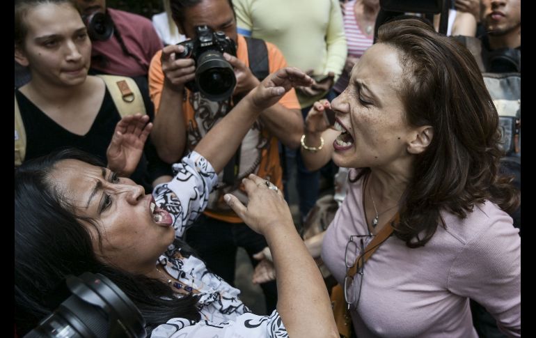 Una simpatizante (i) y una opositora (d) del presidente Nicolás Maduro discuten afuera de la embajada en Ciudad de México. AFP/P. Pardo
