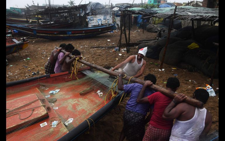 Pescadores llevan un bote a una zona más elevada en una playa de Puri antes de la llegada del ciclón. AFP/D. Sarkar