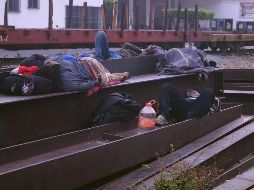 Migrantes centroamericanos descansan sobre las vías de tren en Arriaga. EFE/C. López