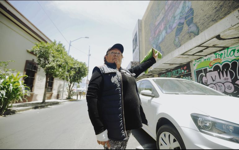 Carmen. Cuida espacios de estacionamiento, convive con una perrita, se resguarda a la sombra de un árbol y es testigo del pasar del tiempo en el emblemático barrio. EL INFORMADOR / F. Atalino