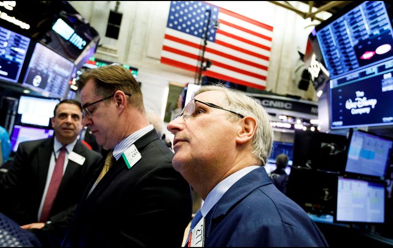 Varios trabajadores operan en la Bolsa de Nueva York este lunes. EFE/J. Lane