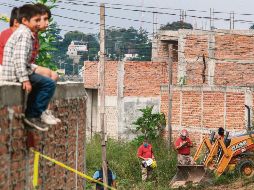 Niños miran el rescate de cuerpos en ctubre de 2018, en la Colonia Agua Escondida. AFP