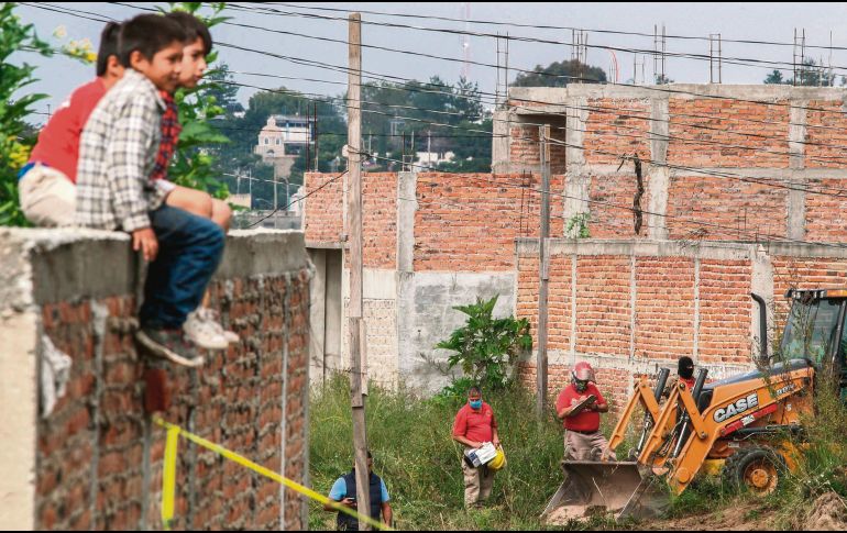Niños miran el rescate de cuerpos en ctubre de 2018, en la Colonia Agua Escondida. AFP