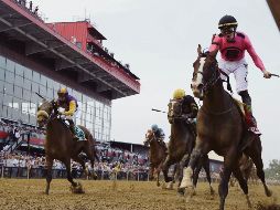 Tyler Gaffalione fue el jockey que montó a “War of Will” (der.) ayer en  la victoria en el Preakness. AP / S. Helber