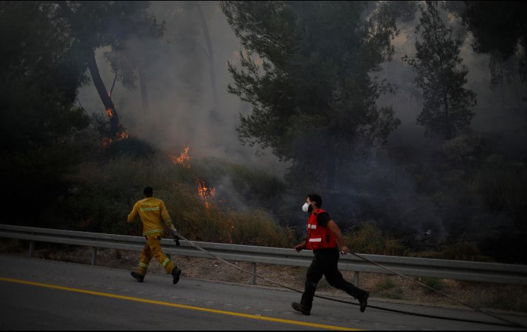 Bomberos trabajan a marchas forzadas para combatir las conflagraciones en medio de nubes de humo. AP/S. Schalit
