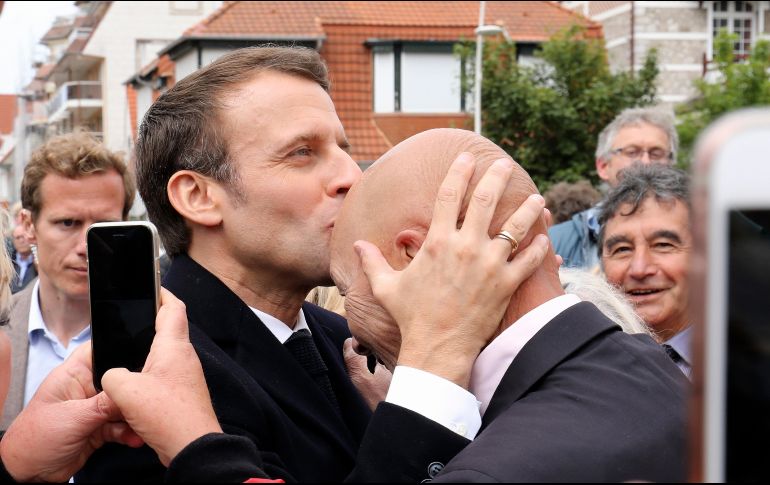 Emmanuel Macron besa a un simpatizante luego de emitir su voto en las elecciones europeas, ayer en Le Touquet, Francia. AP/ARCHIVO
