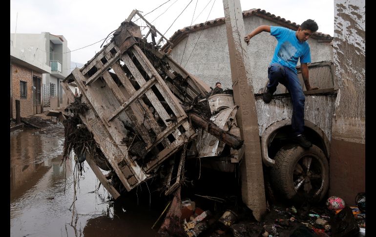 Un joven pasa por vehículo dañado. Una tormenta registrada ayer en la localidad de Apango provocó el desbordamiento del río llamado Salsipuedes. La corriente arrastró a su paso lodo, troncos y vehículos hasta la cabecera municipal de San Gabriel.