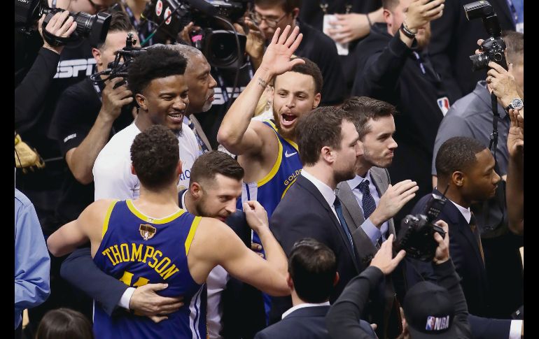 Tras un agónico final, jugadores de los Warriors celebran la victoria. AFP