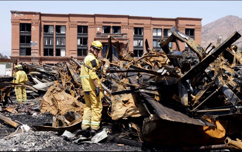 Un bombero examina entre los escombros del siniestro. AP