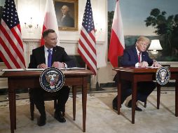 El presidente estadounidense, Donald Trump (d), y el presidente polaco, Andrzej Duda (i), firman un acuerdo bilateral durante su encuentro este miércoles en la Casa Blanca. EFE/S. Thew