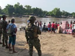Marinos vigilan mientras se realiza el paso ilegal de mercancías en el municipio de Suchiate, Chiapas. SUN