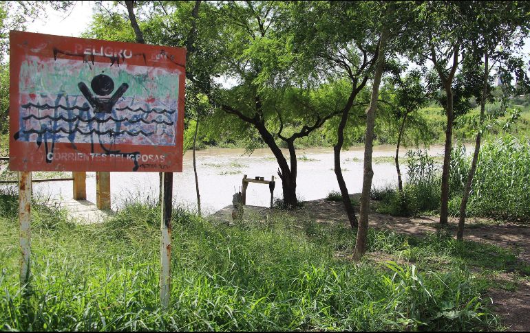 Vista general en la margen del Río Bravo con anuncios preventivos por corrientes peligrosas. EFE/A. Pineda