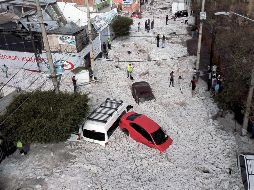 Vialidades de la zona industrial entre Guadalajara y Tlaquepaque amanecieron cubiertas de granizo el 30 de junio, tras una tormenta en la madrugada. Al menos 457 casas resultaron con daños. AFP
