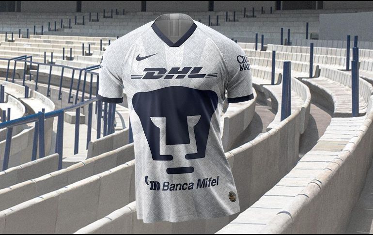 El jersey de local es de color blanco con vivos en azul, cuello y mangas. El Puma del pecho tiene un patrón de inspiración prehispánica que rinde homenaje a jugadores y aficionados. ESPECIAL / @pumas.mx