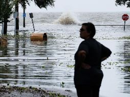 Una mujer observa una carretera inundada poco antes de la llegada de 