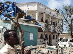 Un hombre revisa los escombros del inmueble tras la explosión y tiroteo en la zona. AP