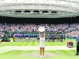 Simona Halep alza su trofeo de campeona tras vencer en la Final a Serena Williams, quien en el papel lucía como favorita. EFE