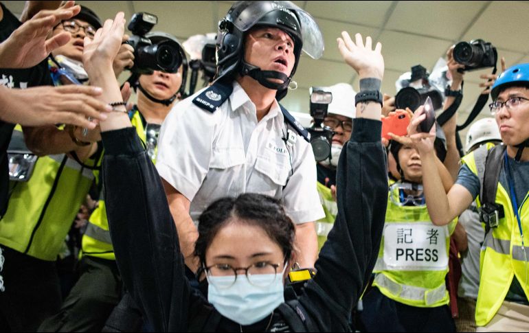 Manifestantes con cascos, máscaras y otros con paraguas colocaron barricadas en cinco carriles y formaron una cadena para pasarse cajas de cartón que utilizaron como escudos. AFP / P. Fong