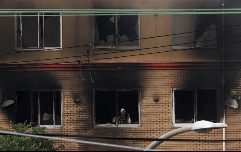 Bombero realiza labores de limpieza tras apagar el siniestro. EFE