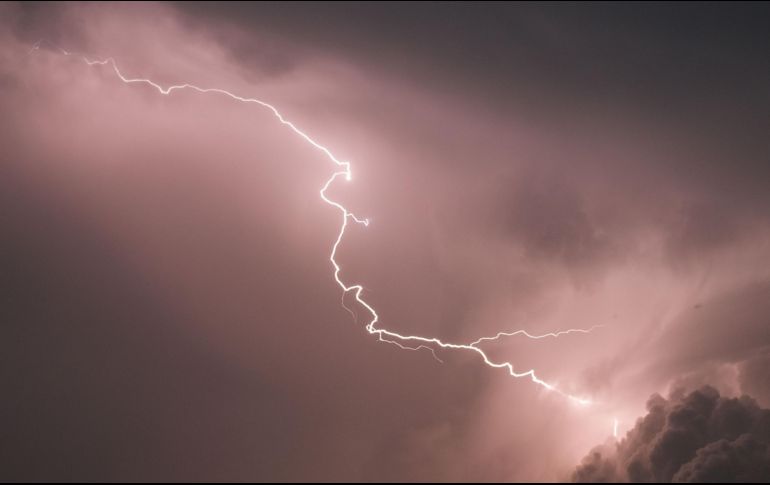 Bañistas se quedaron en la playa luego de que el cielo se oscureció. AFP/ARCHIVO