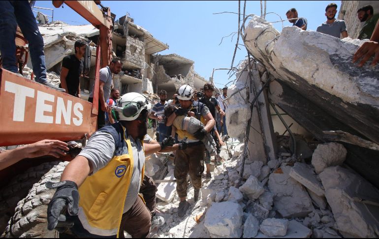 Integrantes de la organización Cascos blancos trasladan a un niño herido tras sacarlo de entre los escombros, luego del ataque de hoy en Maaret al-Numan. AFP/A. Ketaz