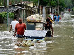 Habitantes trasladan pertenencias tras el desbordamiento de un río en Pathsala, Assam. Las inundaciones han afectado a 20 de 33 estados. AFP/D. Talukdar