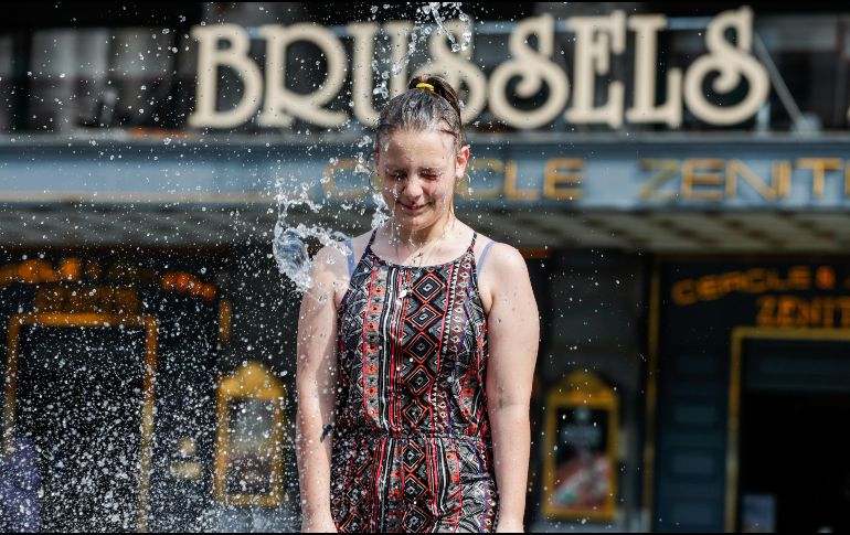 Una joven se mete este viernes a una fuente en Bruselas, la capital belga. El país padece la ola de calor que afecta a Europa. EFE/EPA/. Lecocq
