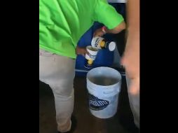 En la imagen se aprecia a una vendedora reciclando la bebida alcohólica en una cubeta para presuntamente ser revendida. TWITTER