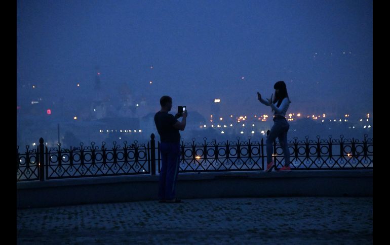 Una mujer posa para una foto entre el humo que cubre la ciudad de Chita.