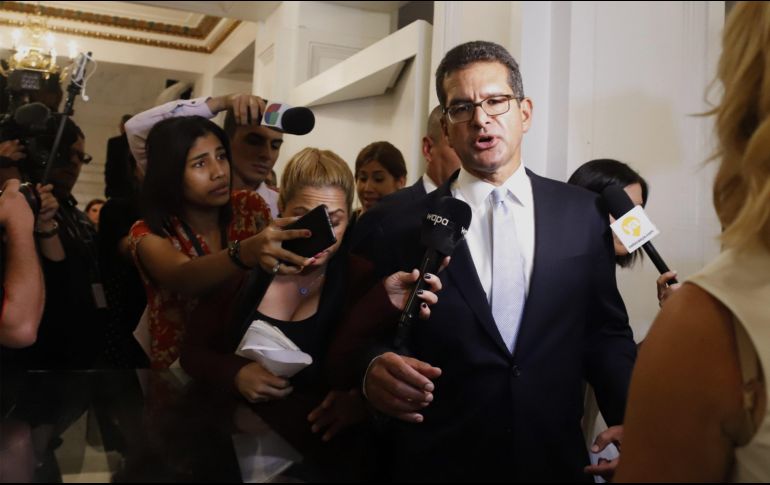 Pedro Pierluisi (c) habla con un grupo de personas a su salida de la vista pública que tuvo lugar en la Cámara Baja, este viernes en San Juan. EFE/T. Llorca