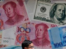 El yuan cayó a poco más de siete por dólar el lunes, lo que ocasionó el desplome de las principales bolsas de valores. AP/K. Cheung