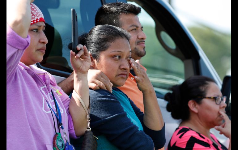 Compañeros y amigos de detenidos observan el operativo de las autoridades en la planta de Morton. AP/R. Solis