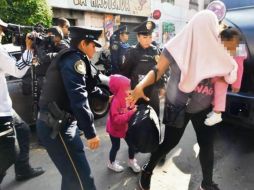 Los oficiales escoltan a los extranjeros tras su cautiverio en una finca. ESPECIAL