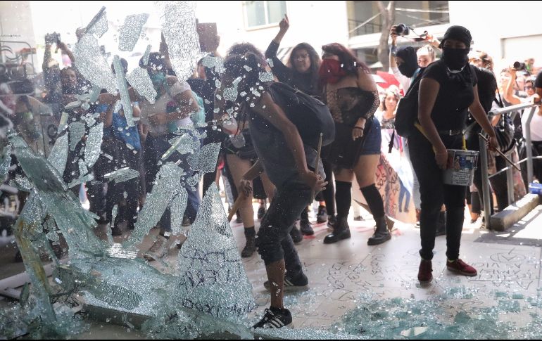 Con cristales rotos y pintas como “No somos estadísticas” y “Muerte a la Policía”, las inconformes se manifestaron afuera de la Procuraduría. EFE/S. Gutiérrez