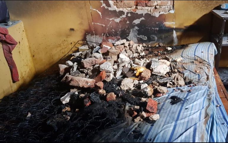 A la llegada de los Bomberos de Guadalajara, los vecinos ya habían rescatado al menor, realizando varios boquetes en la pared de la habitación donde se hallaba. ESPECIAL/ Bomberos de Guadalajara