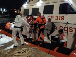 Cuatro migrantes desembarcan del buque de rescate de la ONG española Open Arms para recibir tratamiento médico, en la madrugada del viernes, en el puerto de Lampedusa. EFE/STR