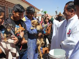 Decenas de vecinos del barrio alteño de Villa Adela empezaron a llegar a la parroquia Cuerpo de Cristo a media mañana, acompañados por perros de todos los tamaños y razas. EFE/G. Baldivieso