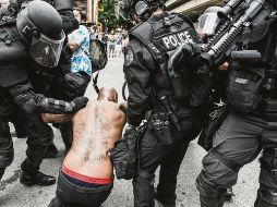 Policías someten a uno de los manifestantes de la marcha en Portland. AFP