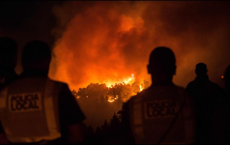 Poicías y habitantes el sábado, mientras observaban el incendio en Gran Canaria. AFP/ARCHIVO