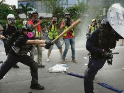 Un inconforme mide fuerzas con un oficial durante las manifestaciones de hongkoneses. AP