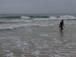 Una persona camina en la playa de Luquillo, en Puerto Rico, previo a la llegada de 