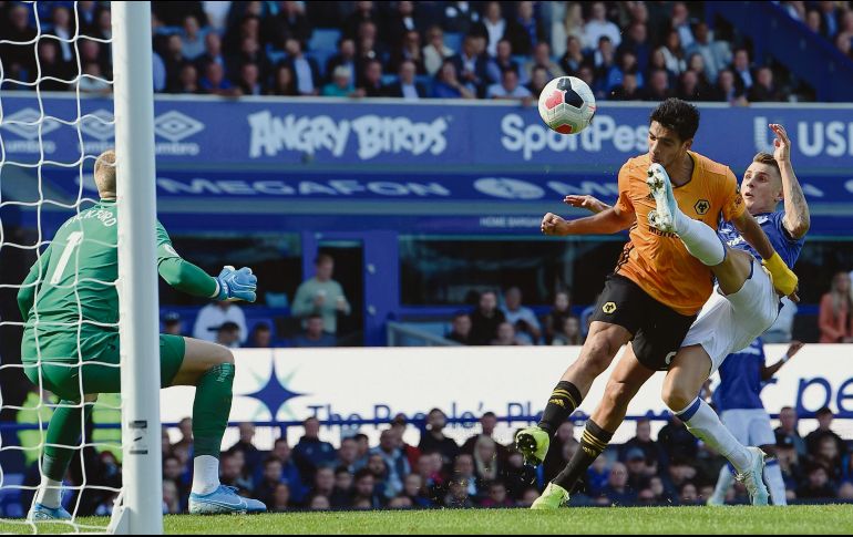 Raúl cabecea la pelota a gol al momento que recibe una patada en la cara. AFP