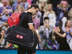 Roger Federer se retira cabizbajo de la cancha tras caer ayer en cinco sets ante Grigor Dimitrov. AP